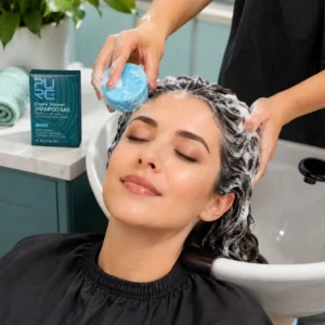 Stylist applying PURC Bio Seaweed Shampoo Bar to a woman's wet hair at a salon basin