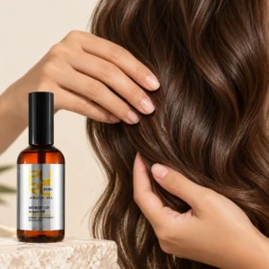 PURC Moroccan Argan Hair Oil beside a hand smoothing oil through wavy hair lengths
